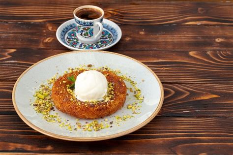 Premium Photo | Turkish dessert kunefe with ice cream ball on wooden ...