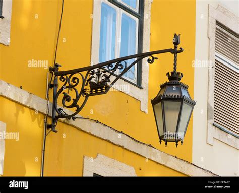 Traditional black wrought iron wall lantern on a yellow wall Stock Photo - Alamy