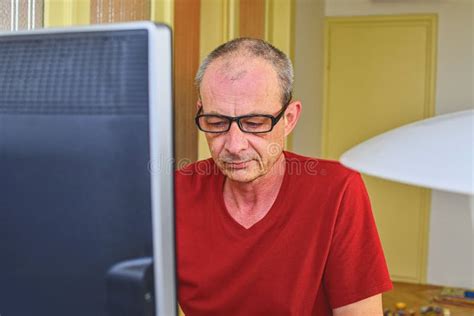 Middle Aged Man with Glasses Sitting at Desk. Mature Man Using Personal Computer. Senior Concept ...