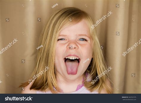 Стоковая фотография 343761575: Young Girl Sticking Her Tongue Out | Shutterstock