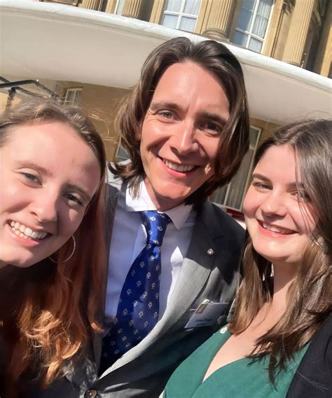 two women and a man are smiling for the camera