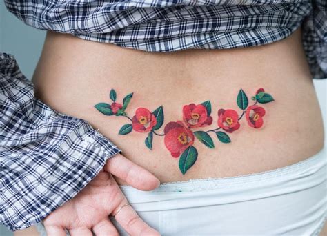 Flower tattoo on the lower back - Tattoogrid.net