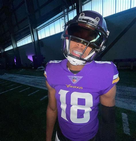 a man wearing a football uniform and helmet standing in front of a ...