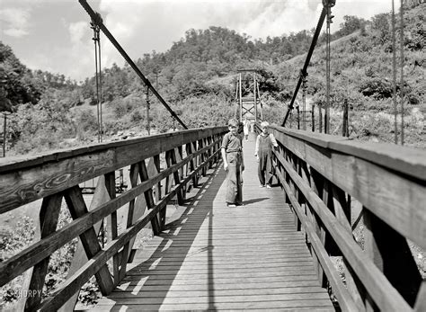 July 1940. Hazard, Kentucky. "Miners' children crossing swinging bridge from their homes into ...