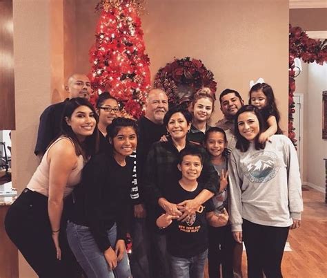 a group of people standing in front of a christmas tree