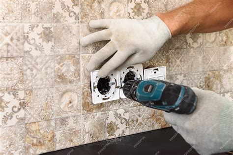 Premium Photo | An electrician is installing switches and sockets on the wall.