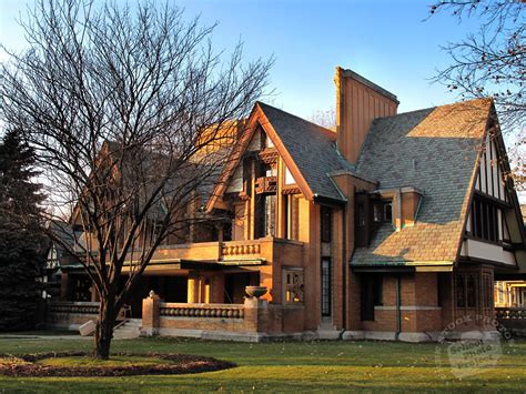 a large brown house sitting on top of a lush green field