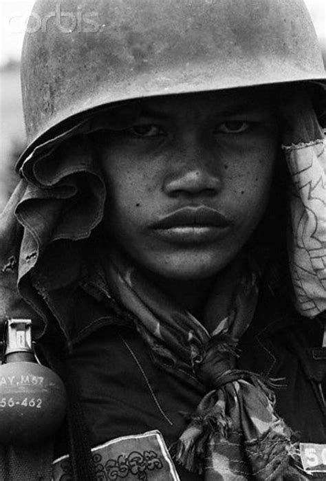 A pro-Lon Nol child soldier smiling to the camera during a lull in fighting against the Khmer ...