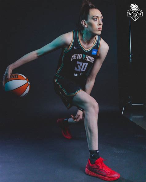 a man holding a basketball while standing in front of a black background with the number 30 on it