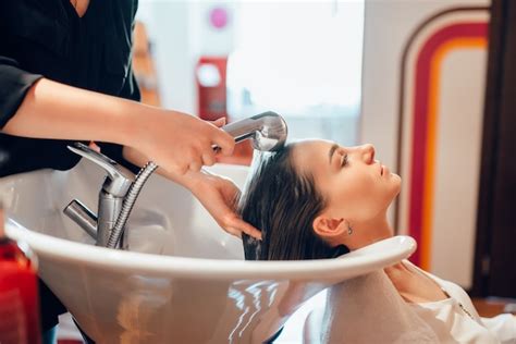 Premium Photo | Hairdresser washes customer hair in basin