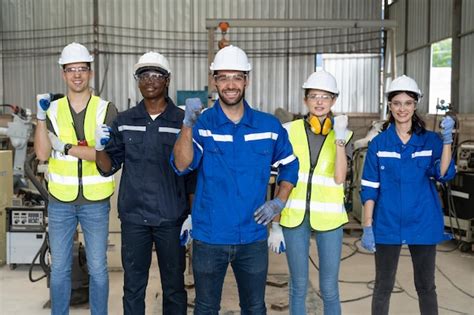 Premium Photo | Group of robotic engineers wear helmets safety standing and raising fist work ...