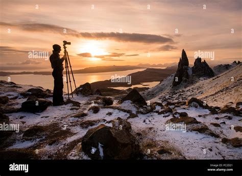 Photographer capturing a winter sunrise at the Old Man of Storr on the Isle of Skye, Scotland UK ...