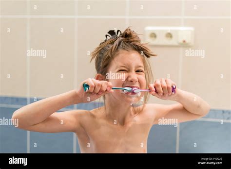 Little girl brushes teeth with two brushes Stock Photo - Alamy