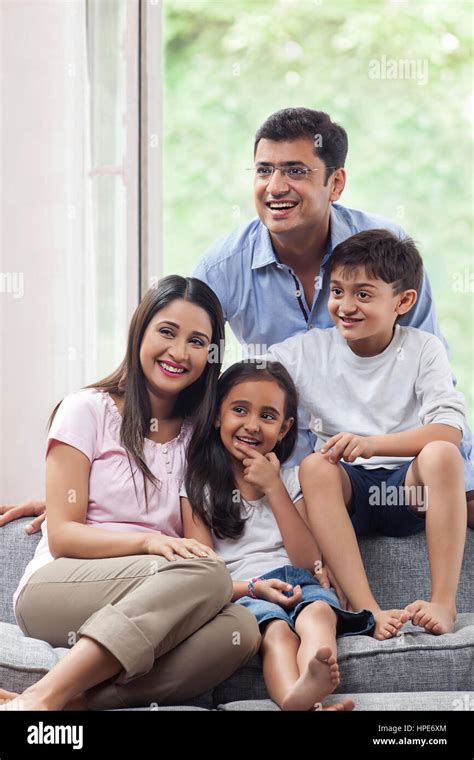 Smiling indian family sitting on sofa together Stock Photo - Alamy