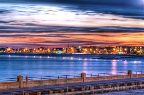 the city is lit up at night by the water