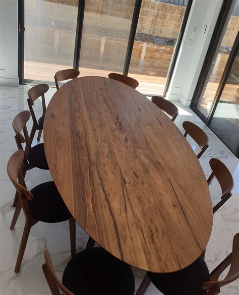a wooden table with six chairs in front of a large glass window that looks out onto the street