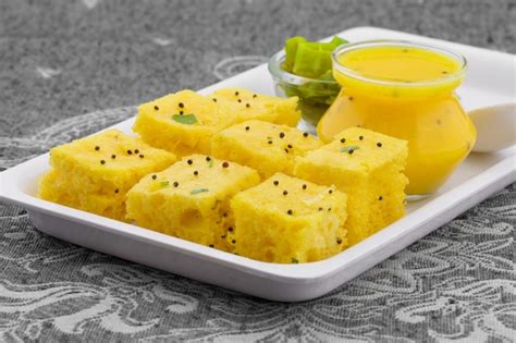 Premium Photo | Indian traditional street food khaman dhokla served with chutney & chilli