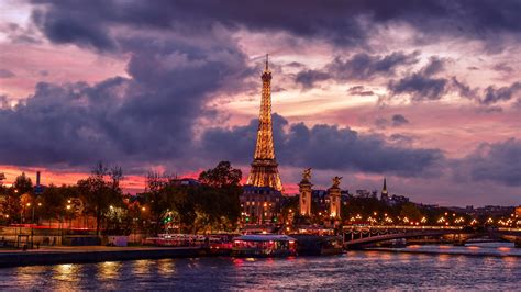 Yellow Lighting Eiffel Tower Paris With Background Of Gray And Purple Clouds During Evening Time ...