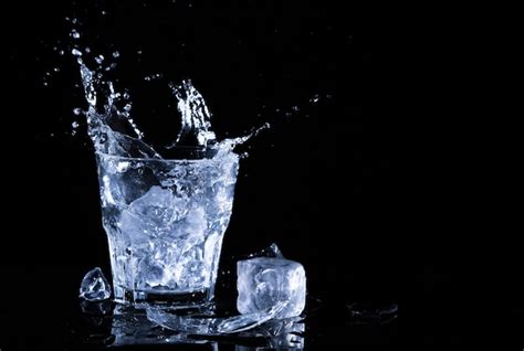 Salpicaduras de agua en un vaso. un vaso de agua fría. agua fría con hielo | Foto Premium
