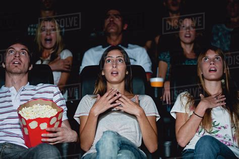 Audience in movie theater with shocked expressions - Stock Photo - Dissolve