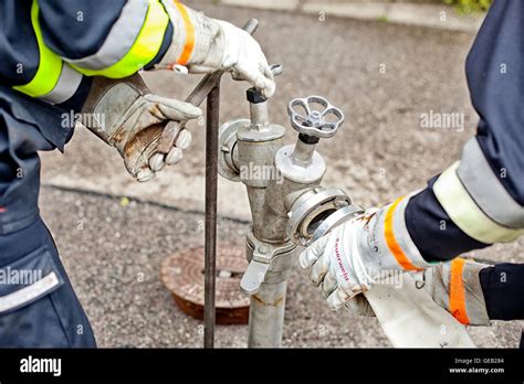 Close-up of firefighters connecting hose to fire hydrant Stock Photo - Alamy