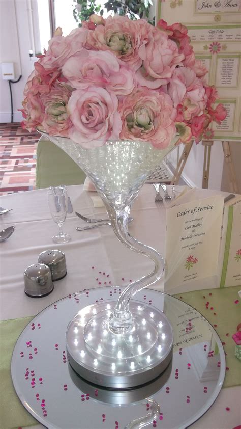 Twisted martini vase weeding centrepiece with pink roses, sitting on an ...