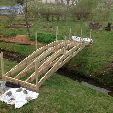 a wooden bridge is being built in the grass