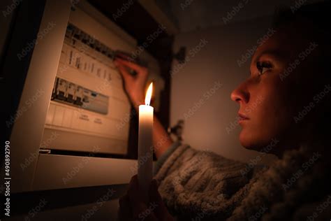 Woman checking fuse box at home during power outage or blackout. No ...