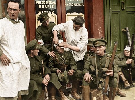 Injured Irish soldiers mend their wounds near a shop after heavy ...