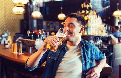 happy man drinking beer at bar or pub | Stock image | Colourbox