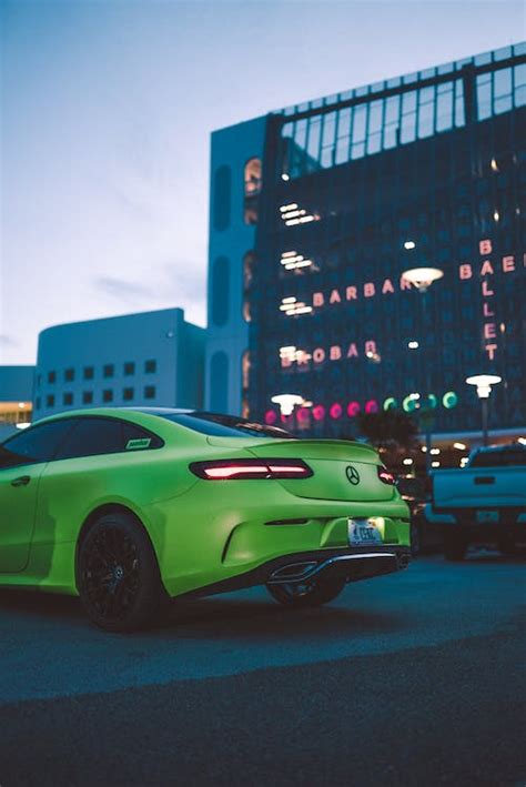 A Green Sports Car Parked in front of a Modern Building · Free Stock Photo