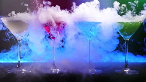 Colorful drinks with dry ice smoke effect. Bartender show and prepared ...
