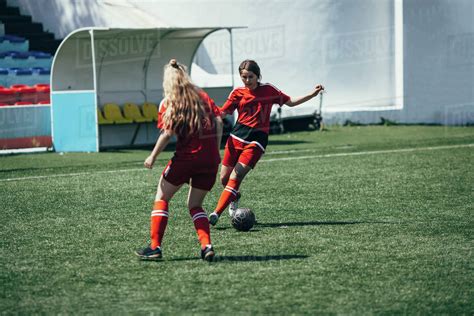 Determined teenagers playing soccer on field - Stock Photo - Dissolve