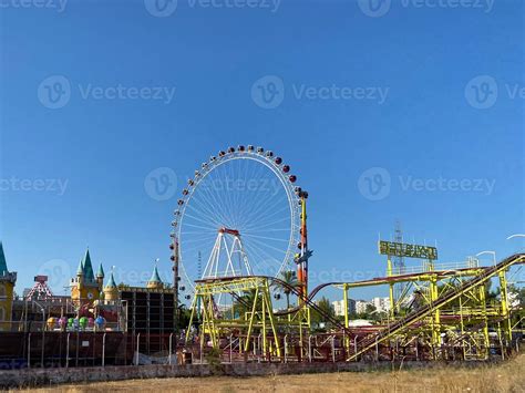 Ferris wheel and roller coaster rides at pier pacific park at sunset ...