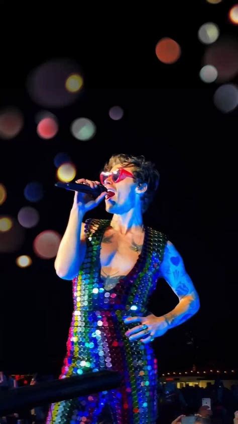 a woman in a colorful dress singing into a microphone