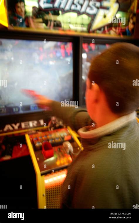 Boy Playing Shooting Game in Arcade Stock Photo - Alamy