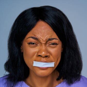 Premium Photo | Close-up terrified female face with sealed mouth by white stripe. emotions concept