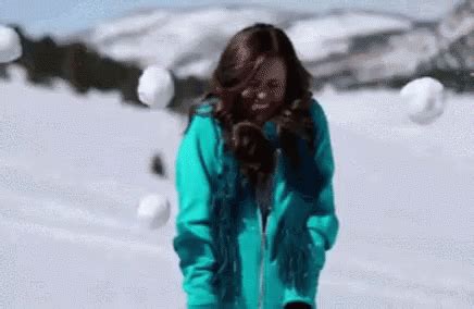 a woman standing in the snow with skis on her feet and wearing a blue ...