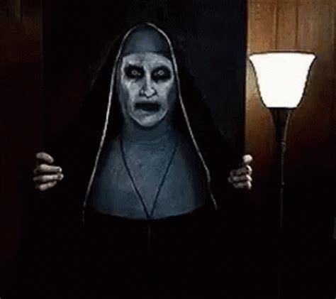 a woman dressed as a nun holding a lamp