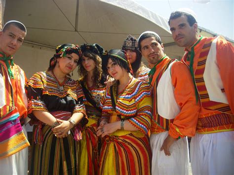 a group of people standing next to each other wearing colorful clothing and headgear