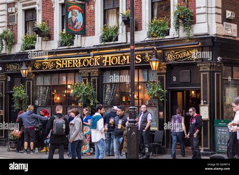 Crowd drinking in street outside the Sherlock Holmes pub in Queen Stock ...