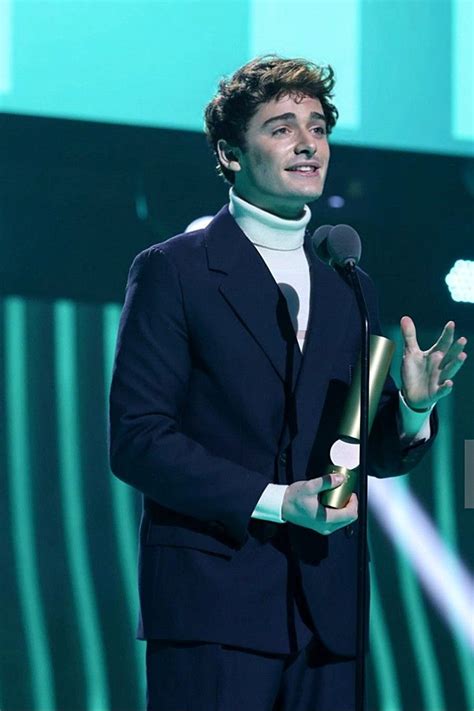 a man standing in front of a microphone on stage