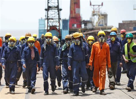 Workers wearing protective gear arrive to dismantle a decommissioned ship at the Alang shipyard ...