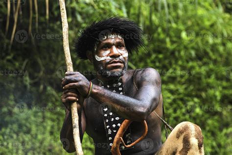 Portrait of Dani Tribe man wearing koteka, traditional clothes of Papua. Dani tribe men looking ...