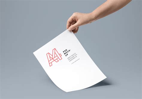 Hand holding A4 Paper Mockup - Mockup World