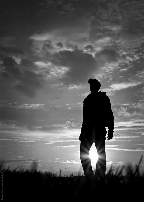 "Silhouette Of Man Standing In A Field Against Sunlight" by Stocksy Contributor "Simone Wave ...