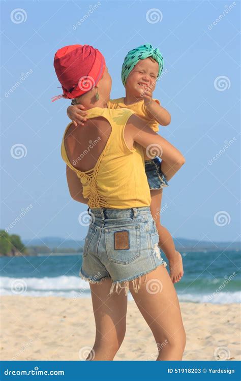 Young Mother Hugging Her Daughter on Beach Stock Image - Image of jeans, identical: 51918203