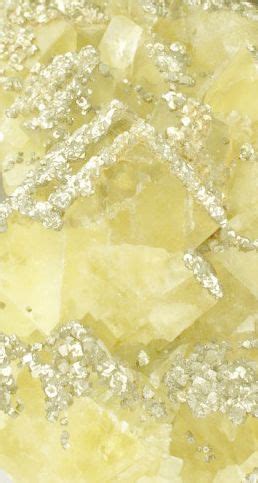 some yellow and silver crystals on a white surface