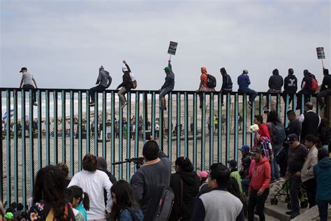 'Caravan migrants' scale US-Mexico border wall during protest | SBS News