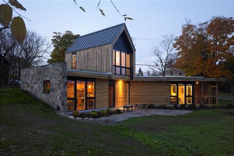 a modern house is lit up at night in the fall or early evening with ...